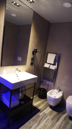 a bathroom with a sink and a toilet and a mirror at Leoni Hotel & Private Spa in Citta' Sant'Angelo