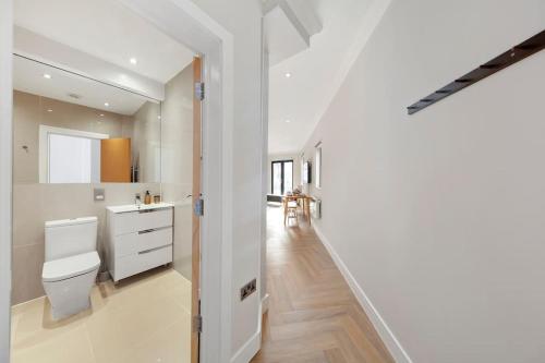 a white bathroom with a toilet and a sink at Amazing 2bed flat 10min to Wimbledon tennis courts in London