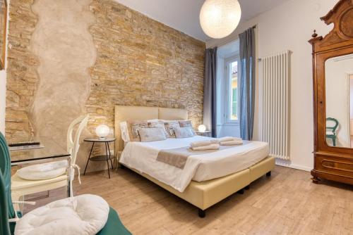 a bedroom with a bed and a brick wall at Palazzo Rivola in Bergamo