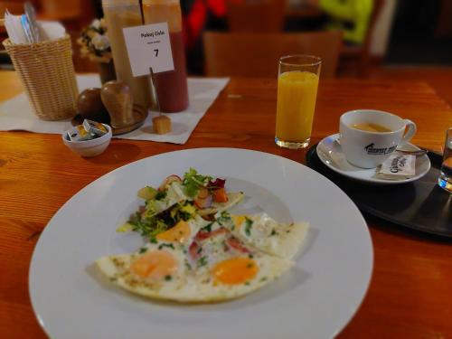 a plate of food with eggs and a cup of orange juice at Penzion Country Steak Restaurant in Lanškroun