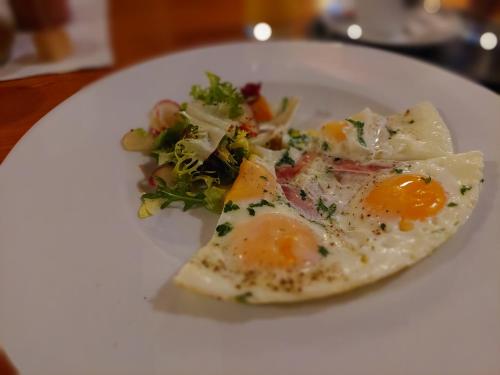 a plate with two eggs and a salad on it at Penzion Country Steak Restaurant in Lanškroun