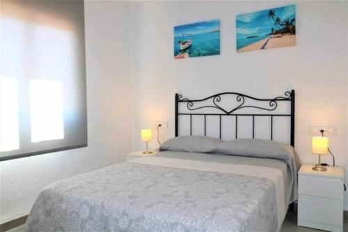 um quarto com uma cama e 2 candeeiros nas mesas em 3F 1ª línea de playa con vistas al mar em Calpe