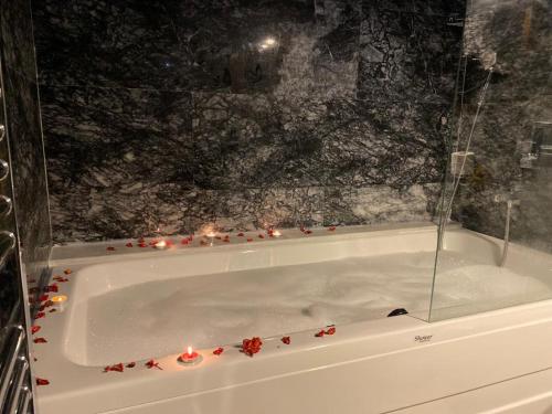 a bath tub with candles and red flowers on it at Foremanson Cave Hotel in Nar