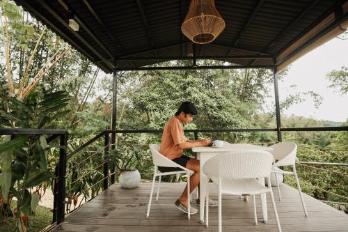 a woman sitting at a table on a porch at 150 Peakway Mountain Resort in Dalaguete