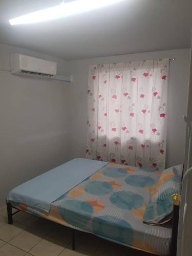 um pequeno quarto com uma cama com uma cortina em Marigold Roomstay em Labuan