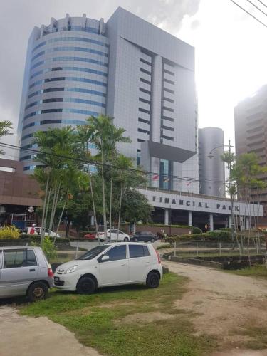 dois carros estacionados em frente a um grande edifício em Marigold Roomstay em Labuan