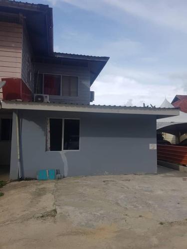 uma casa com uma parede azul e uma garagem em Marigold Roomstay em Labuan