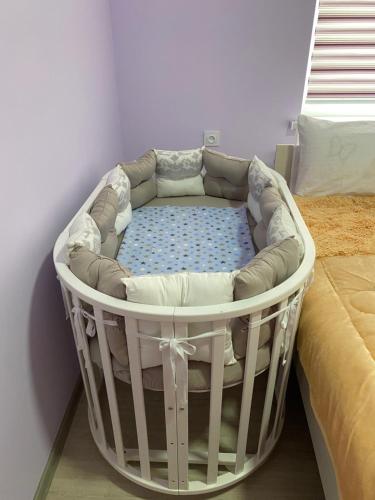 - un lit dans un lit bébé blanc dans l'établissement Apart House, à Türkistan