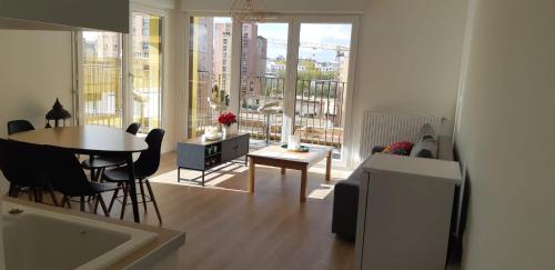 uma sala de estar com uma mesa e cadeiras e uma grande janela em La Terrasse - big apartment & terrace 80m2 - metro 17 min from Paris em Bagneux