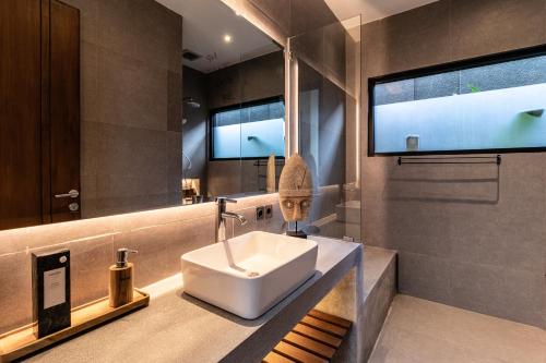 La salle de bains est pourvue d'un lavabo et d'un grand miroir. dans l'établissement Villa Slide by Bali Superhost, à Ubud