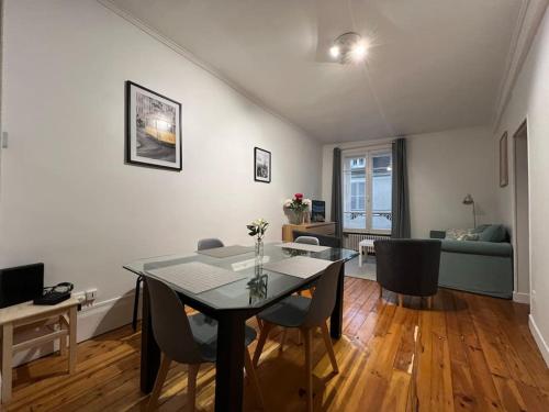 une salle à manger et un salon avec une table et des chaises dans l'établissement La pause allongée - Fontainebleau Hypercentre, à Fontainebleau