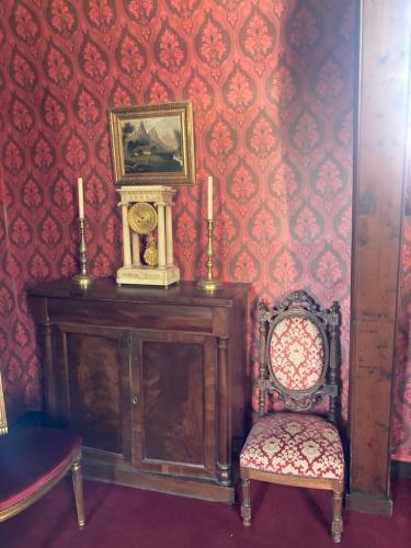 a room with a clock and a chair at Château De Swann in Illiers