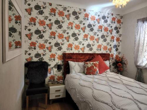 1 dormitorio con 1 cama y papel pintado con motivos florales en Boutique style accomodation near Busselton Jetty, en Busselton