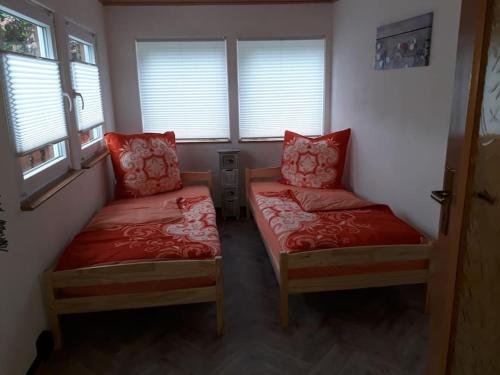 a room with two beds and two windows at Bungalow blühende Oase in Sebnitz