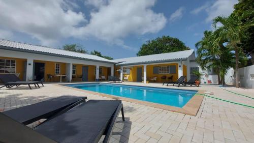 a house with a swimming pool in front of it at J&L Resort in Willemstad