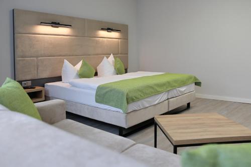 a hotel room with two beds and a couch at Hotel und Restaurant Kranichsberg in Woltersdorf
