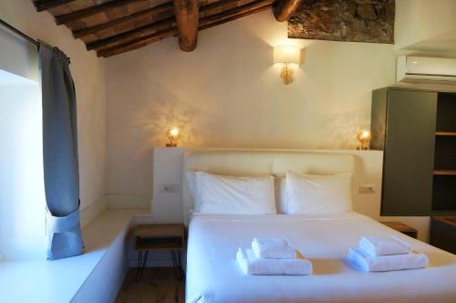 a bedroom with a white bed with towels on it at THE ROMAN WAY OPERA in Rome