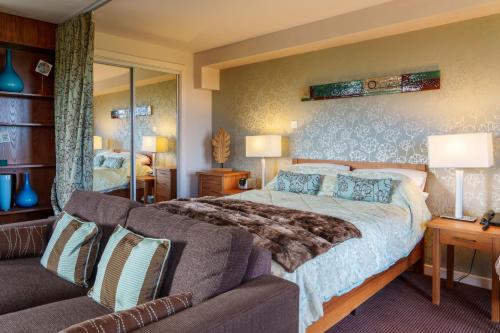 a bedroom with a large bed and a couch at 12 Ullswater Suite - Whitbarrow Village in Penruddock