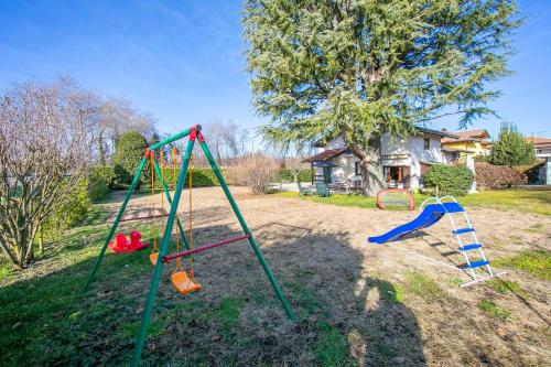 einen Spielplatz mit zwei Schaukeln im Hof in der Unterkunft Cedar House Villa Few Minutes From Lake - Happy Rentals in Angera