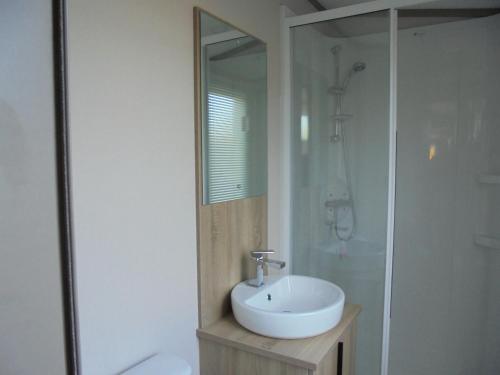 uma casa de banho branca com um lavatório e um chuveiro em 6 Berth Grange Leisure Park Mablethorpe Stonewood em Mablethorpe
