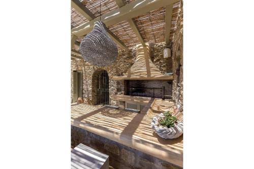 a living room with a stone wall at Elite Mykonos Villa - Villa Roxane - Private Pool - 6 Bedrooms - Beachfront - Ftelia in Dexamenes