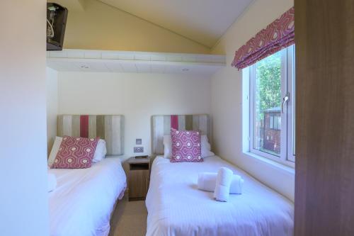 2 camas en una habitación con ventana en TipTree Holiday Home in South Devon en Chudleigh