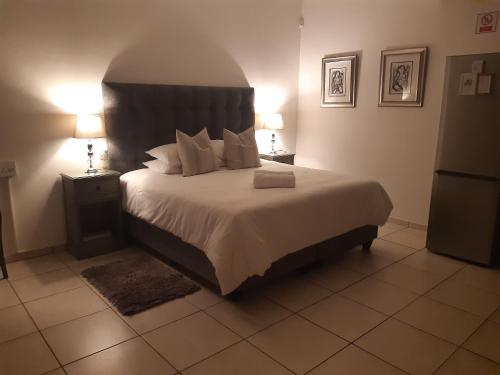 um quarto com uma cama grande e 2 candeeiros em Aspasia Agency CC em Mariental