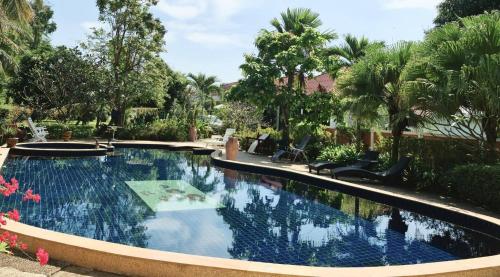 Ban Sa的住宿－Room in Bungalow - Schones Bungalow mit gemeinschaftichem Ausenpool und 2km vom Sandstrand enfernt，棕榈树庭院内的游泳池
