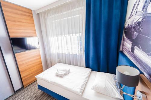 a small room with a bed and a window at Hotel Polski in Mielec