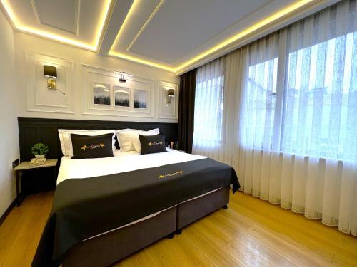 a bedroom with a large bed and a large window at Angel's Home Suites - Angel Group Hotels in Istanbul