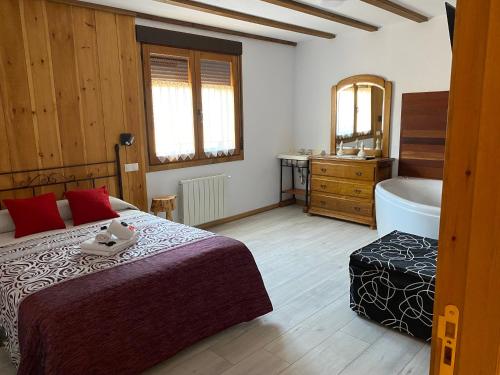 een slaapkamer met een bed en een badkamer met een bad bij El Busque Casa Rural in Casla