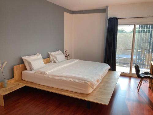 uma cama grande num quarto com uma janela grande em Moocoworking em Loei