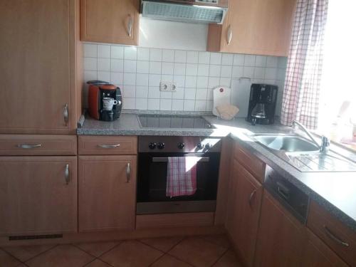 a kitchen with a stove and a sink at Landhaus im Grünen - Carpe Diem in Grammendorf