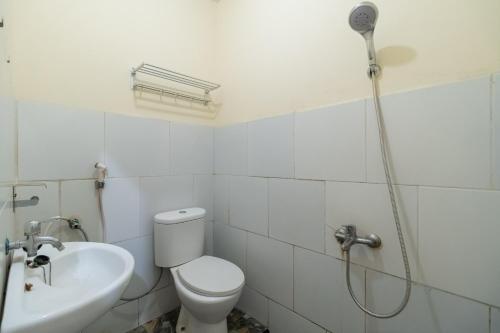 y baño con ducha, aseo y lavamanos. en RedDoorz Syariah At Jalan Raflesia Nusa Indah Bengkulu en Bengkulu