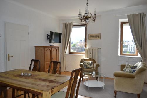 Ferienwohnungen am Stadtpalais في بيرنكاستل كويز: غرفة معيشة مع طاولة وكراسي خشبية