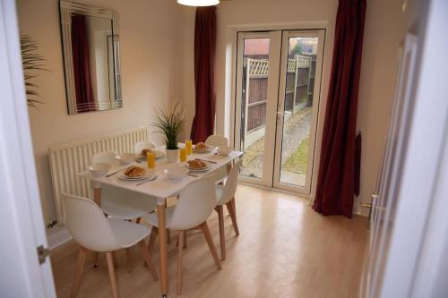 - une table blanche avec des chaises et de la nourriture dans l'établissement Charming 3 Bed House in Bristol, à Bristol