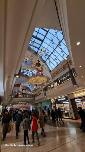 um grupo de pessoas andando em um shopping center em Blueville House, Bluewater, 4 Bedroom Houses, Greenhithe, Dartford, Kent-Hosted by Castile Accommodations Ltd em Kent