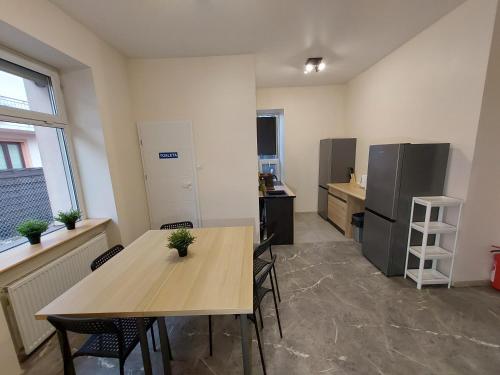 een keuken met een tafel en stoelen en een koelkast bij Noclegi Słodki Sen 2 in Lublin