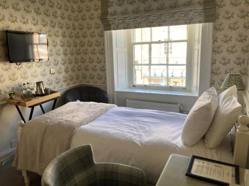 a hotel room with a bed and a window at The Swan at Tarporley in Tarporley
