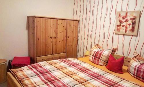 una camera da letto con un letto con cuscini rossi di Landhaus im Grünen - Carpe Diem a Grammendorf