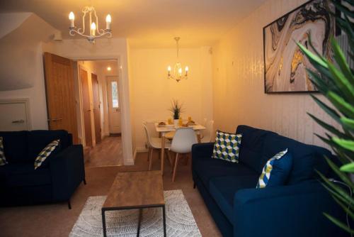 ein Wohnzimmer mit einem blauen Sofa und einem Tisch in der Unterkunft Spacious 3 Bed House in Bristol in Bristol