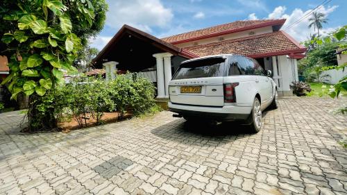 a white car parked in front of a house at Flamingo Villa in Jaffna