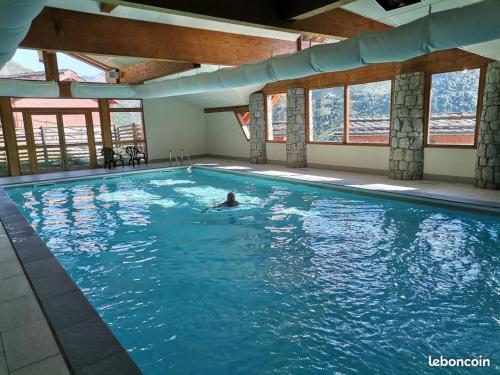 a person swimming in a large swimming pool at Chalet C4 Les Marmottes in Valmeinier