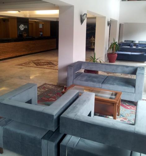 a lobby with blue seats and a table at Surtel Hotel in Kusadası