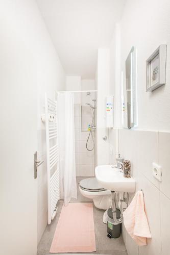 a white bathroom with a toilet and a sink at TM Studio in Dortmund