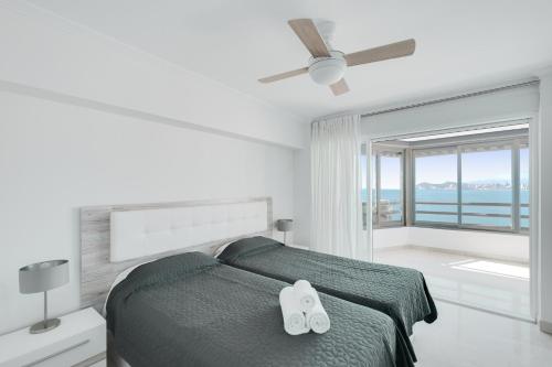 sypialnia z łóżkiem i wentylatorem sufitowym w obiekcie Levante Sunset Luxury apartment Don Miguel w mieście Benidorm