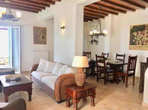 - un salon avec un canapé et une salle à manger dans l'établissement Mykonos Dot - The Villas, à Mykonos