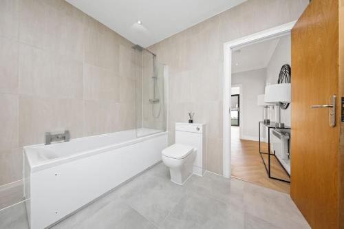 ein Badezimmer mit einem WC, einer Badewanne und einem Waschbecken in der Unterkunft 3bed Penthouse 10min to Wimbledon tennis courts in London