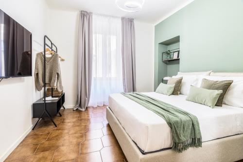 um quarto com uma grande cama branca e uma janela em BePlace Apartments in Porta Garibaldi em Milão