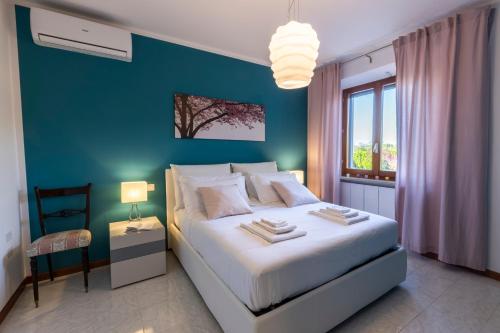 a bedroom with a white bed and a blue wall at DOLF - Villa Elisa - Intera Villa in Tolentino